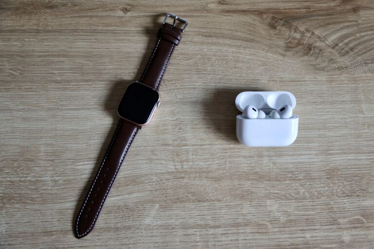 Smartwatch and wireless earbuds on a wooden desk