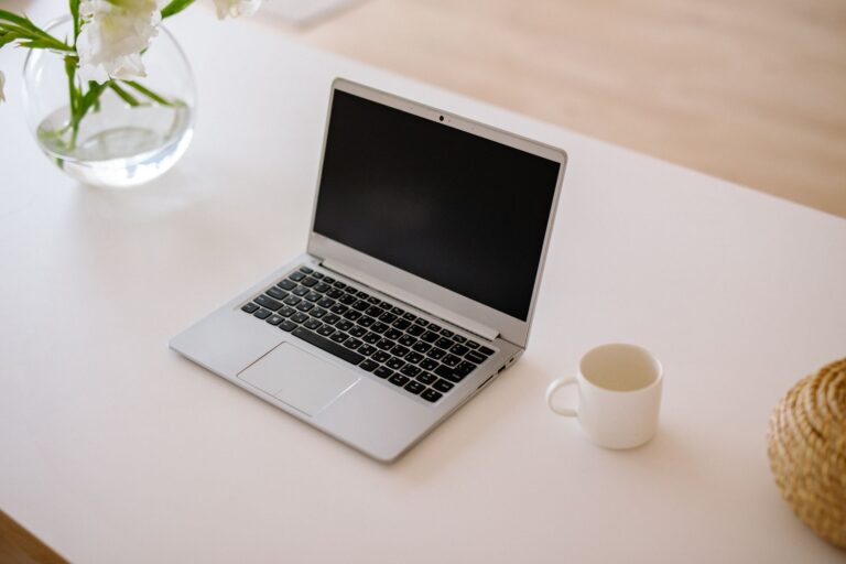 Open laptop and coffee mug on a bright, tidy desk